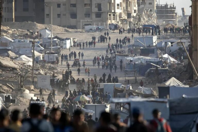 Refugiados palestinos caminan entre escombros en Gaza durante bombardeos israelíes